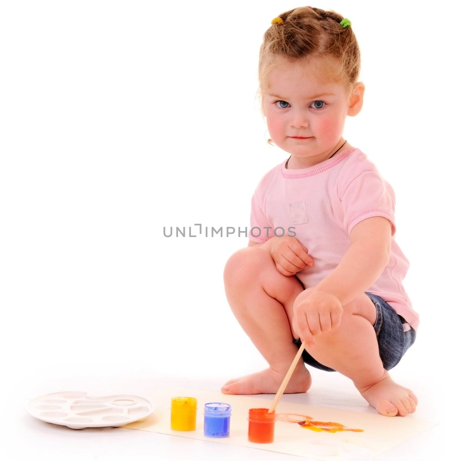 Small blonde girl with paintbrush and paints on white