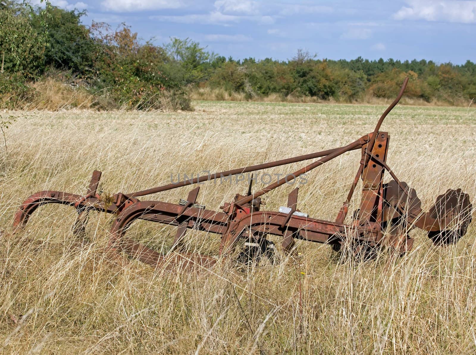 old agricultural machine, abandoned in a field