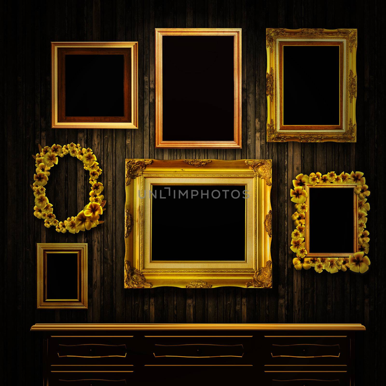 Gallery display - vintage gold frames and a chest of drawers on an old timber wall
