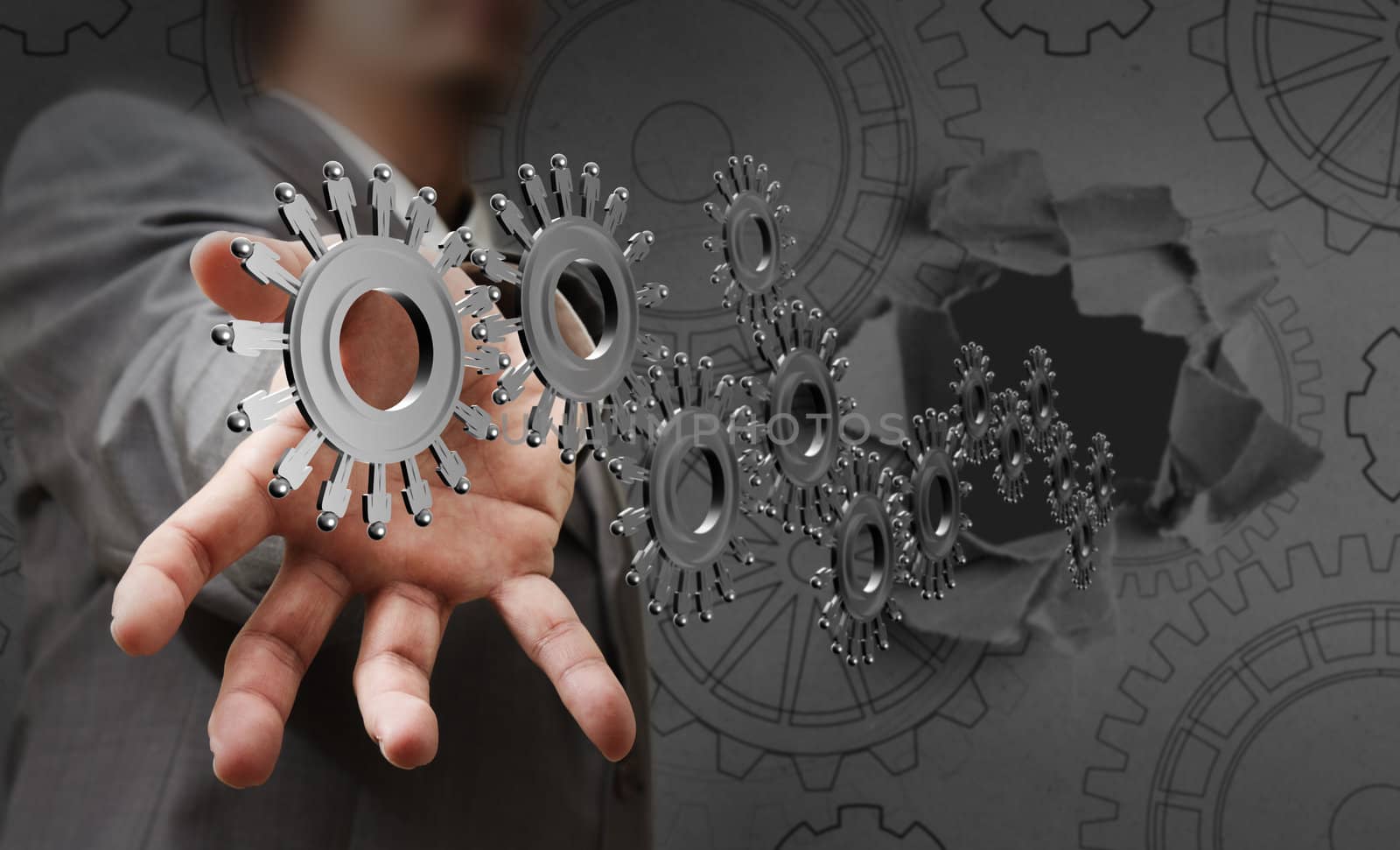 businessman hand shows people cogs as concept