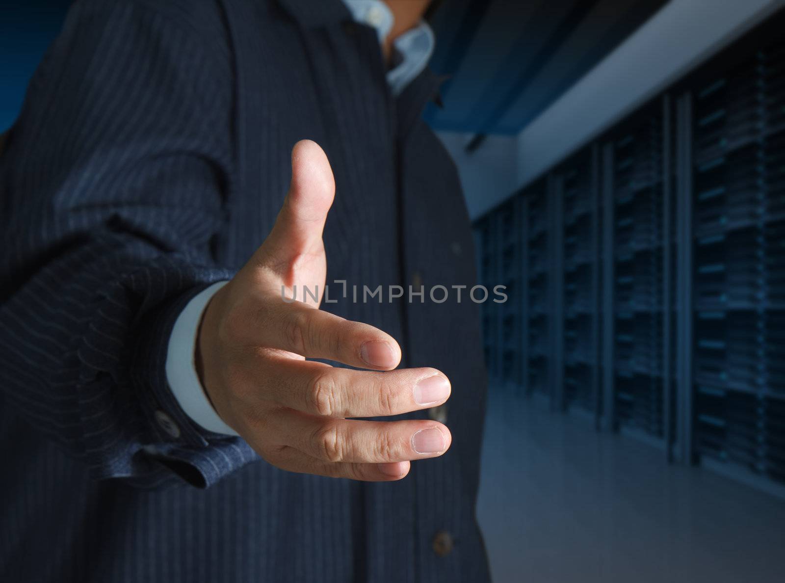 close up businessmen offer hand shake in a technology data center