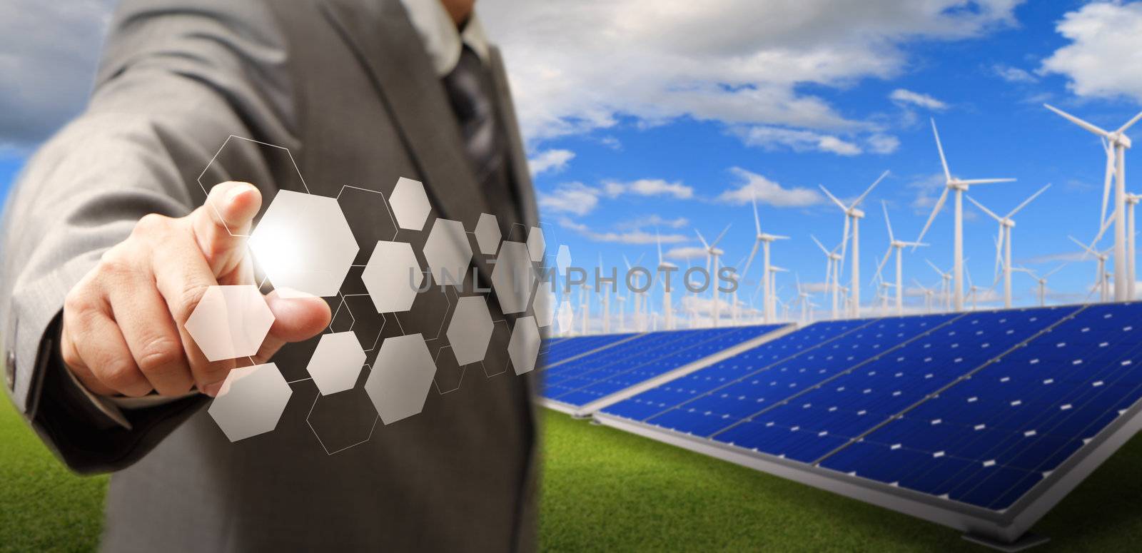 business man hand point virtual buttons and wind turbine and solar farm as concept