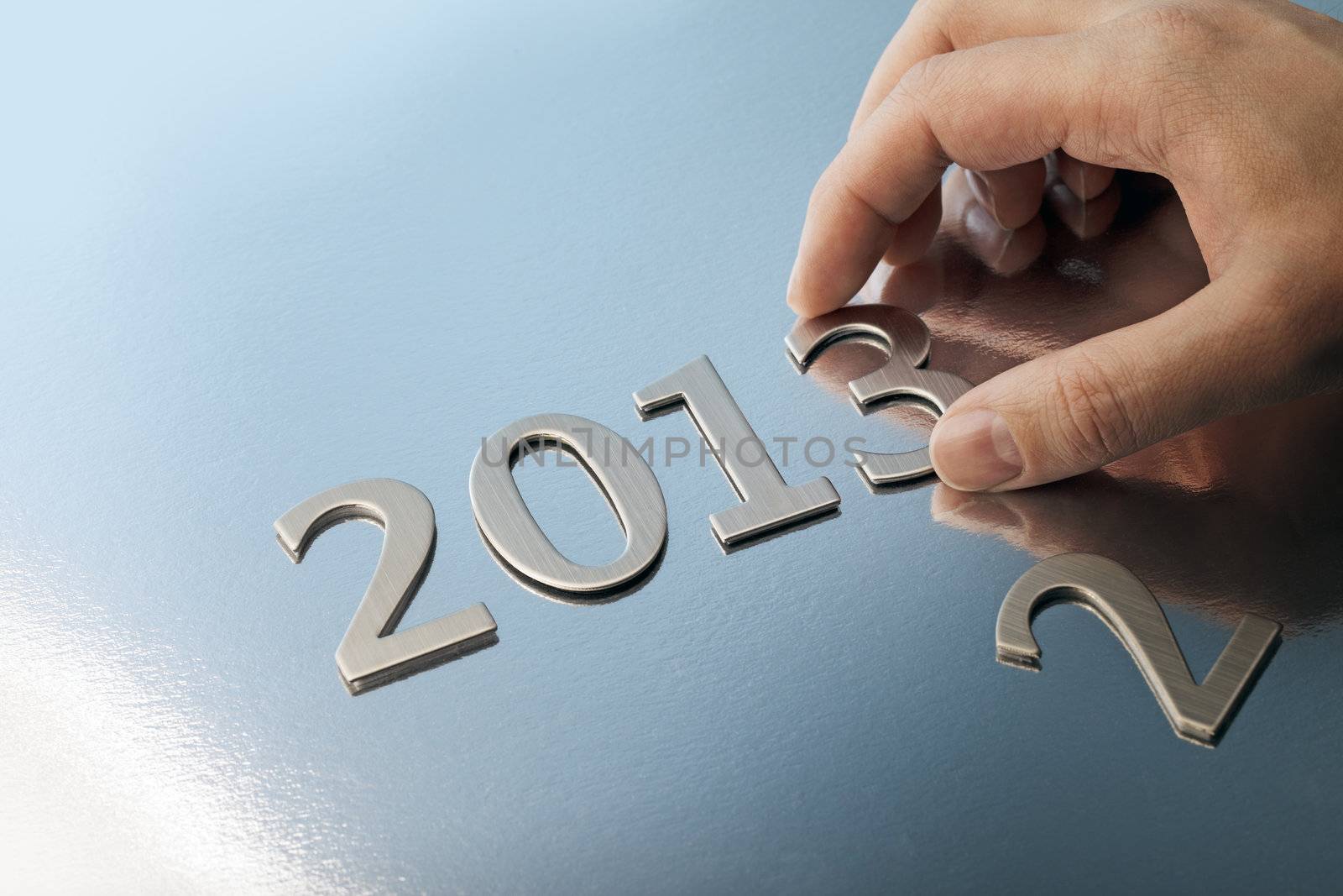 Hand adjusting the year number to 2013.