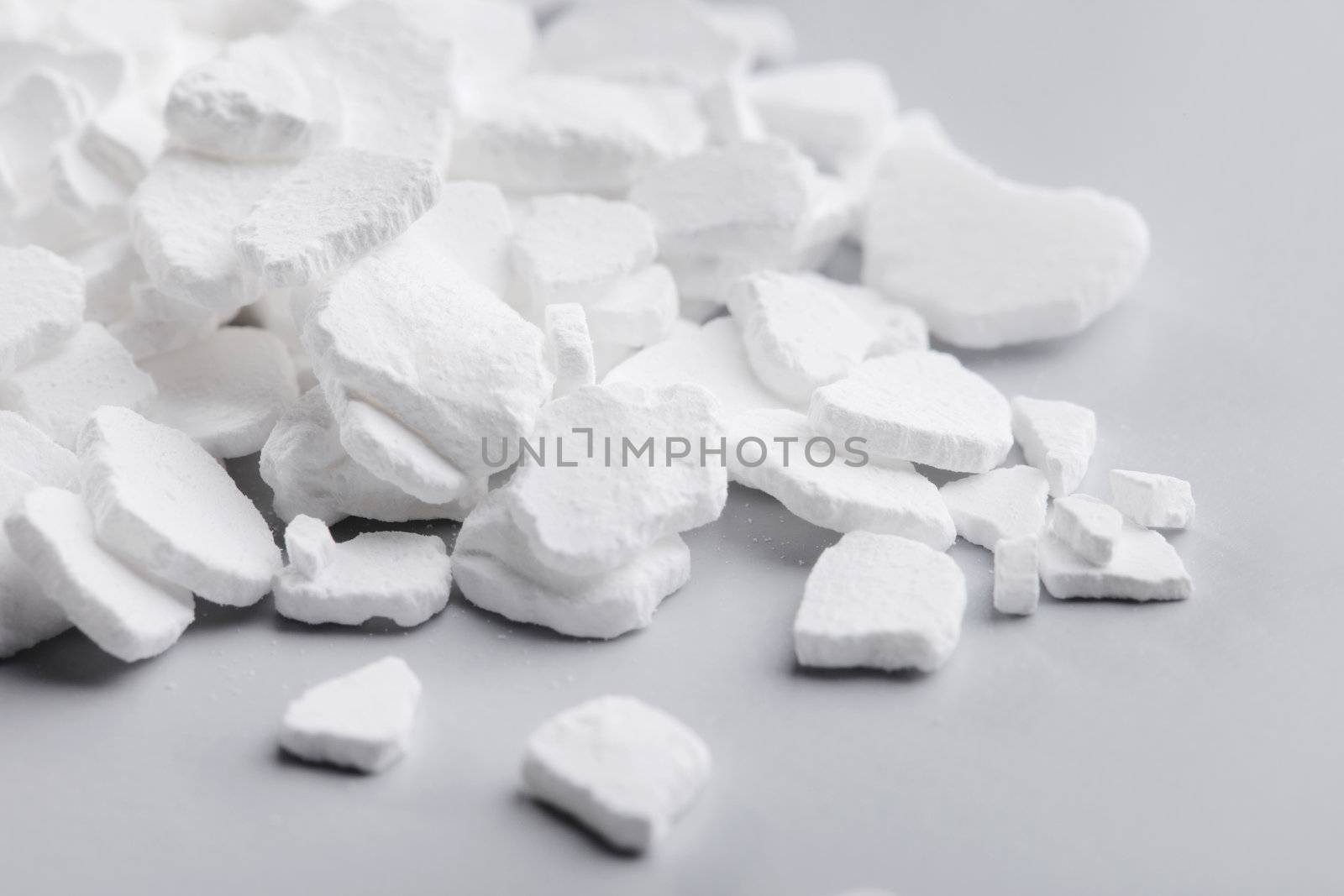 Calcium chloride (CaCl2) flakes. Common applications include brine for refrigeration plants, ice and dust control on roads, and desiccation. 