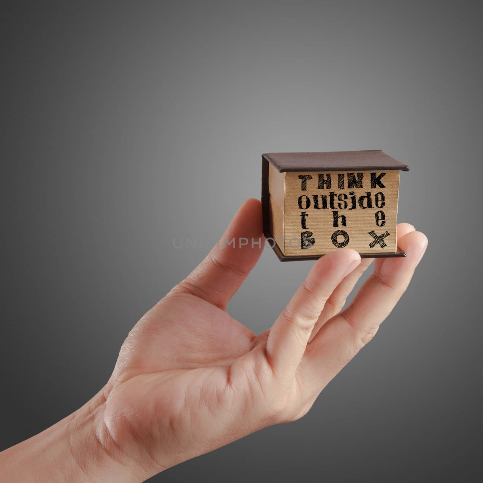 hand shows a book of concept of "think outside the box"