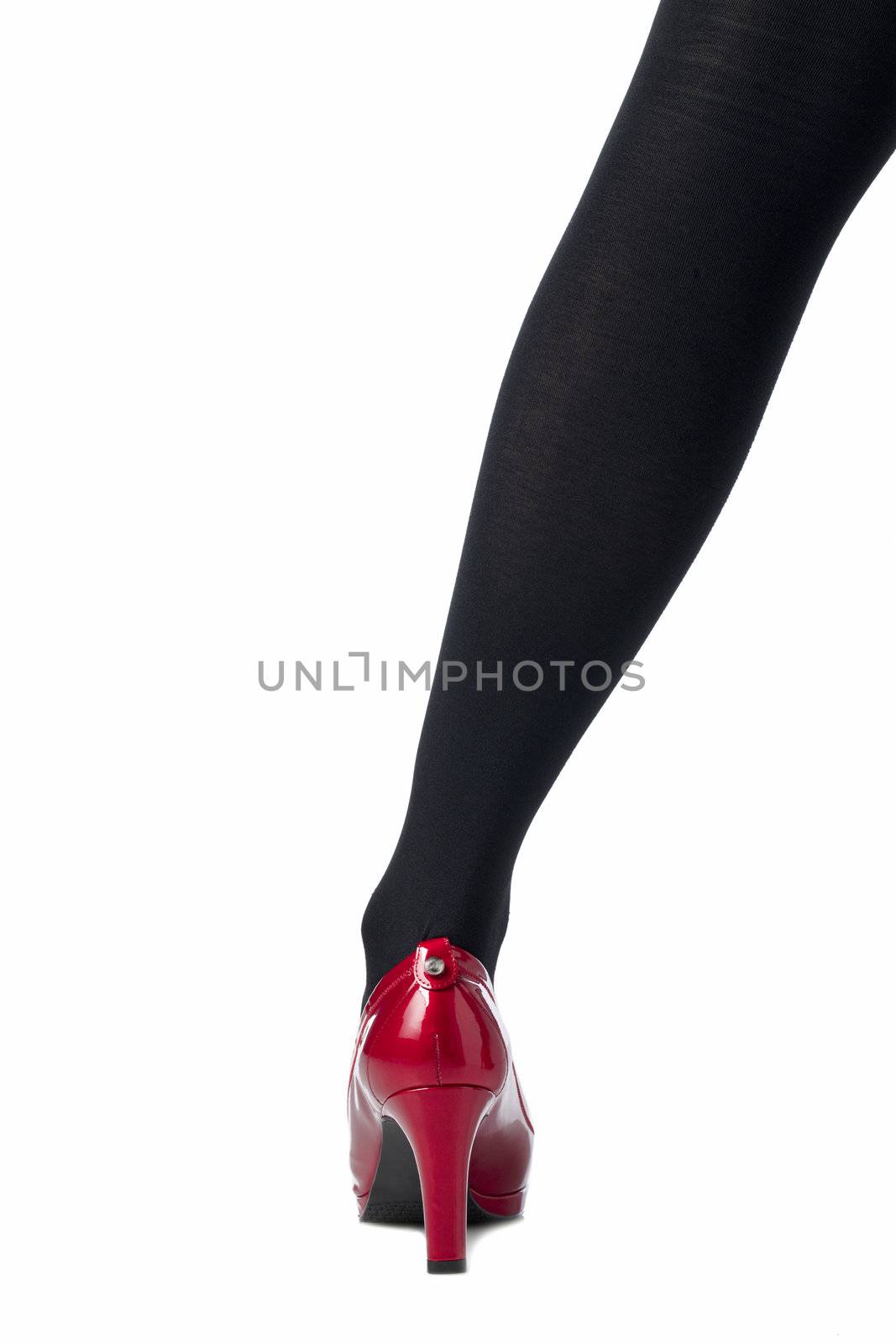 Close up image of female leg with black stocking and red shoes against white background