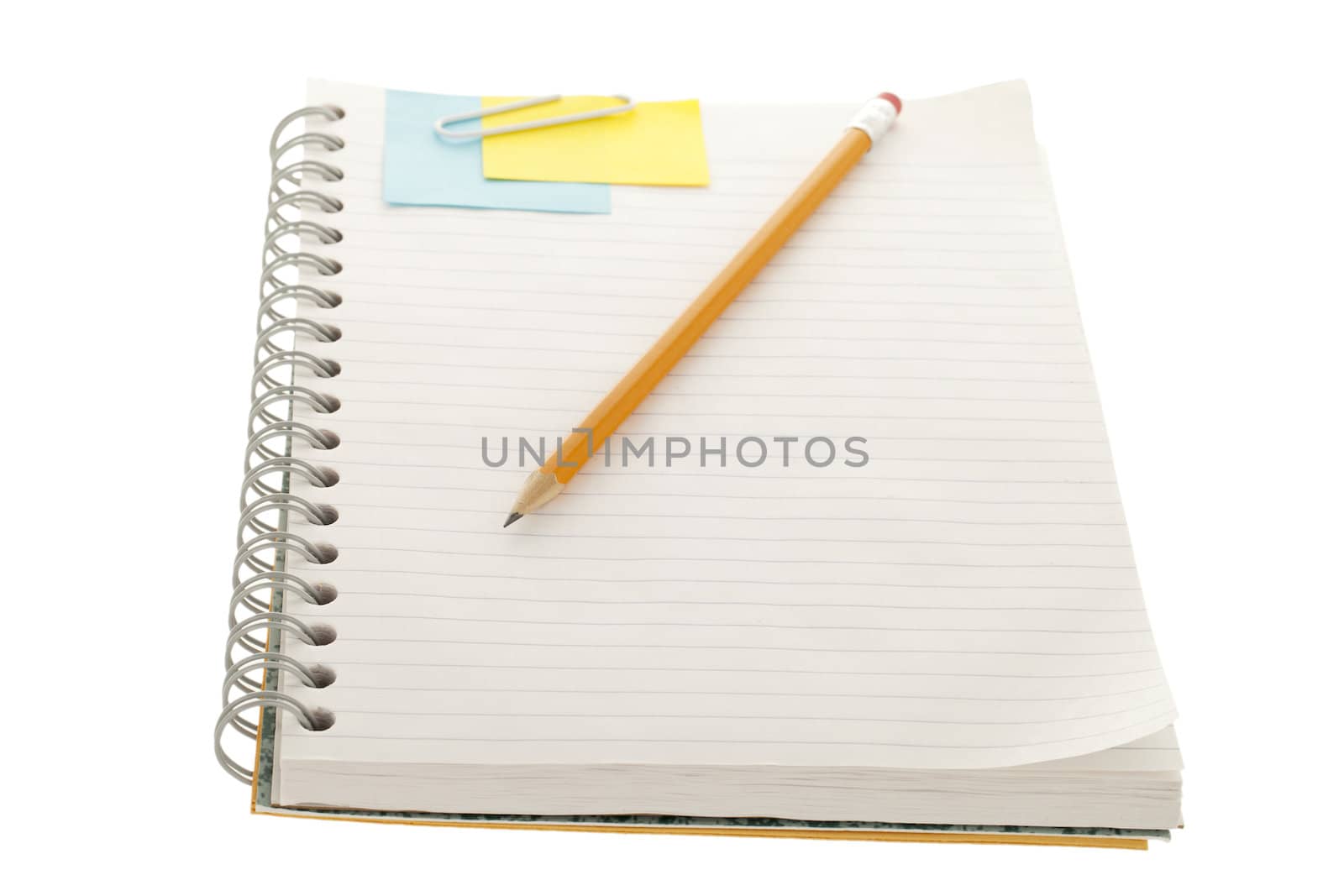 Notebook with adhesive note, paper clip and pencil in a close-up image