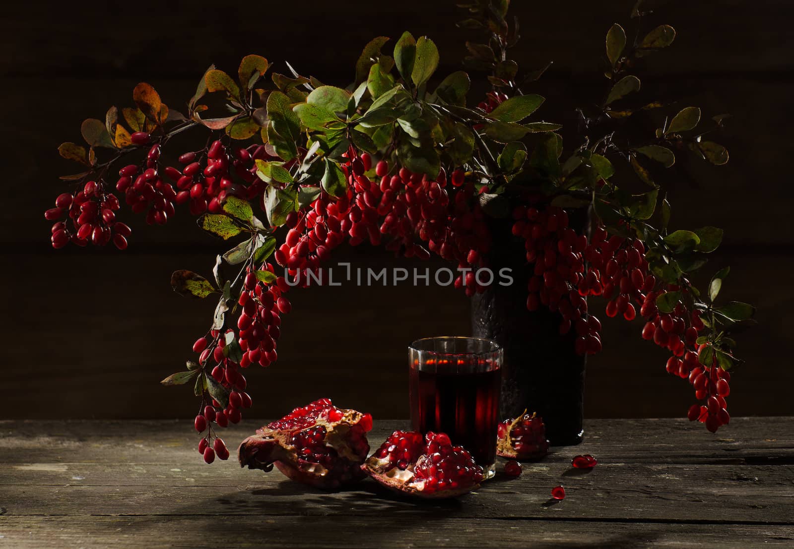 pomegranate and barberry berries on wooden background