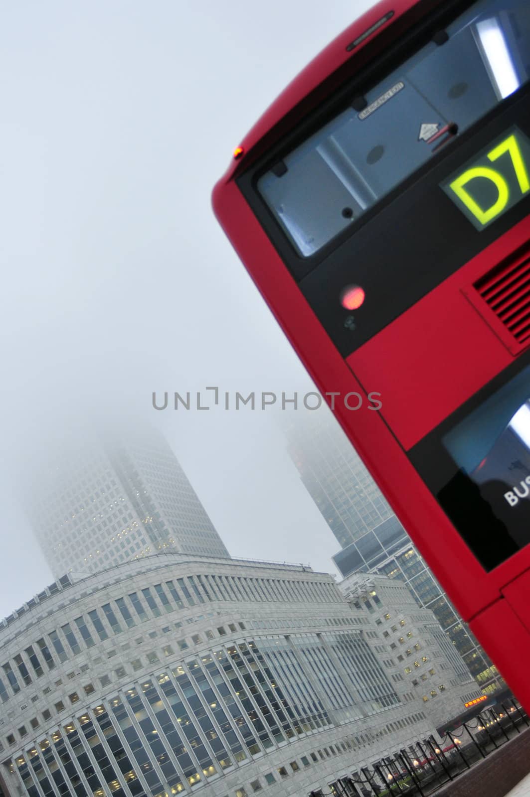 generic image of london city with red bus high business buildings and fog