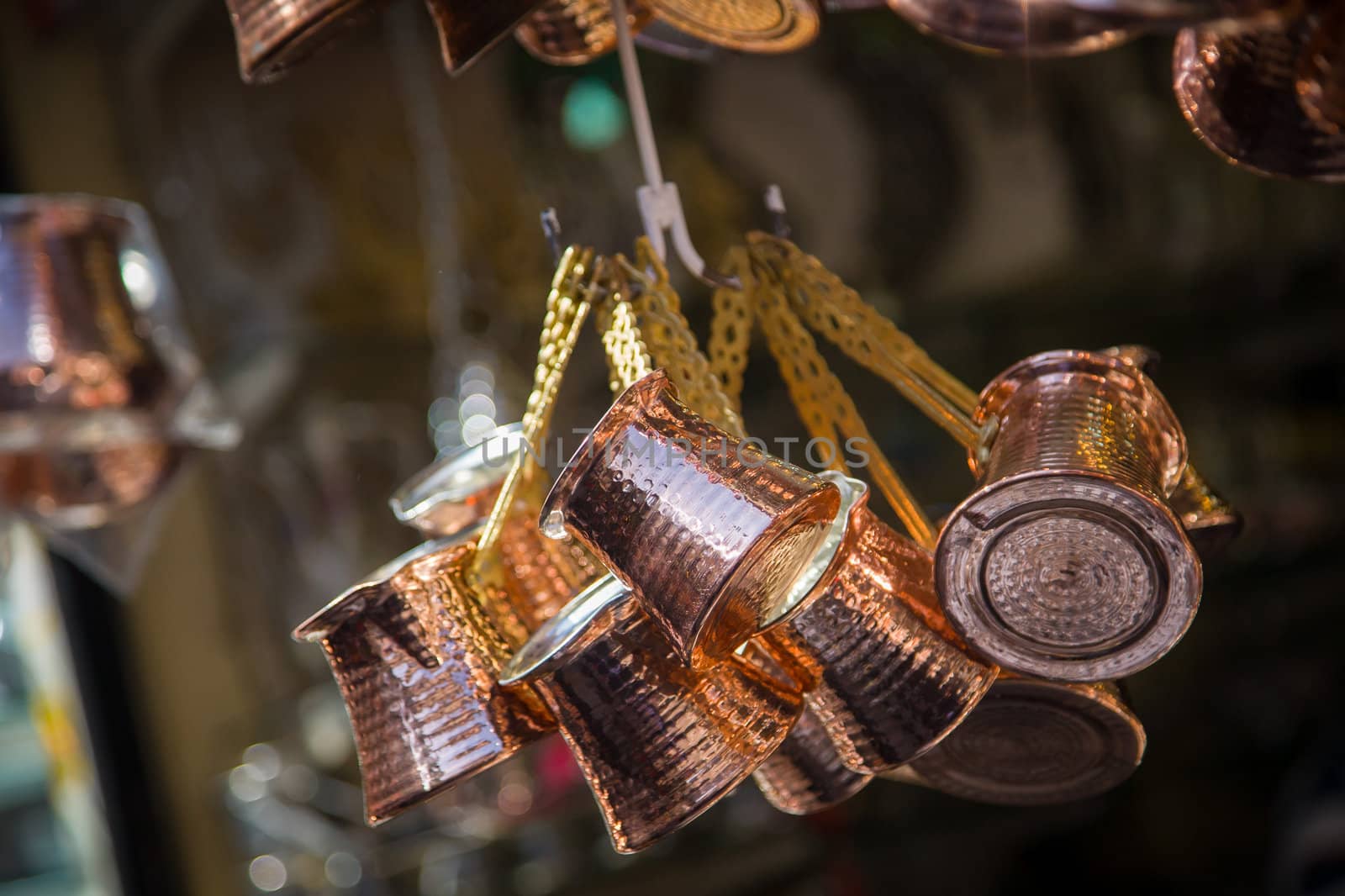 Close up photo of a bunch of copper coffee pots hanged up in a market in Istanbul