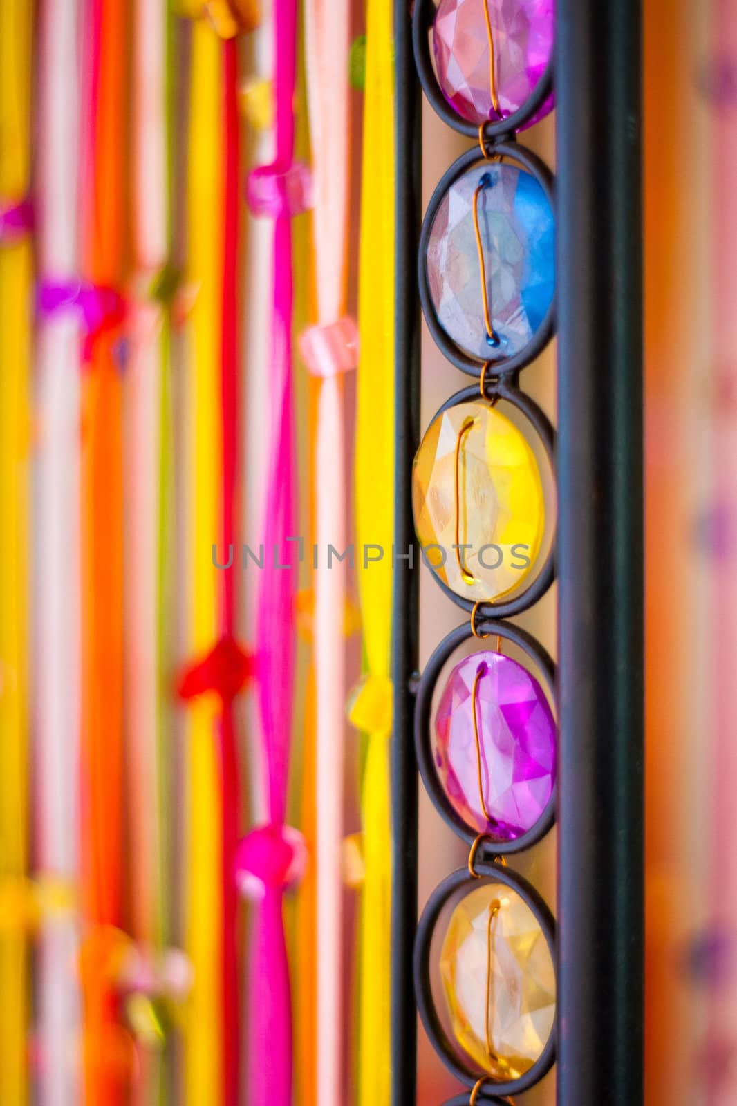 Close up photo of a colourful stone row ornamentation and colourful ribbons in the background in nature light