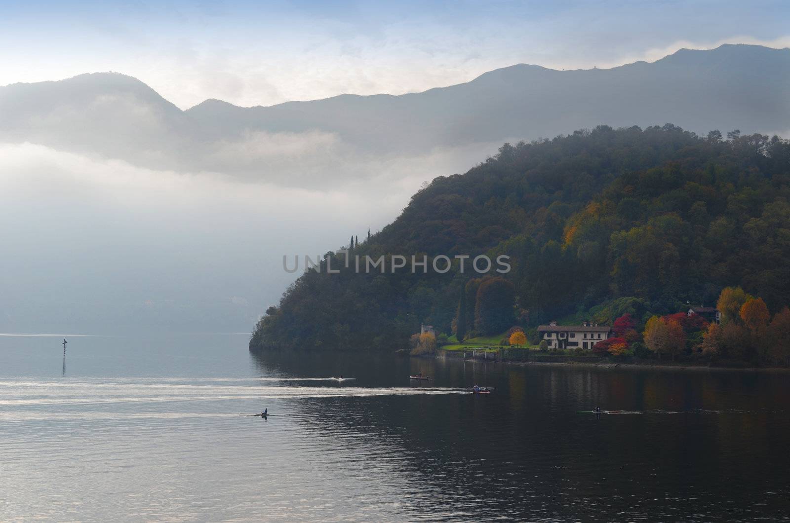 Beautiful view of lake Como (Italy) in autumn with canoes 