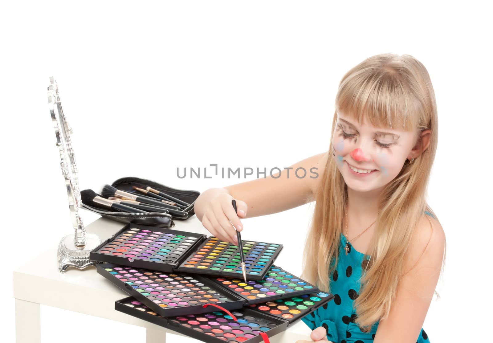 Little girl paints his face makeup, on white background