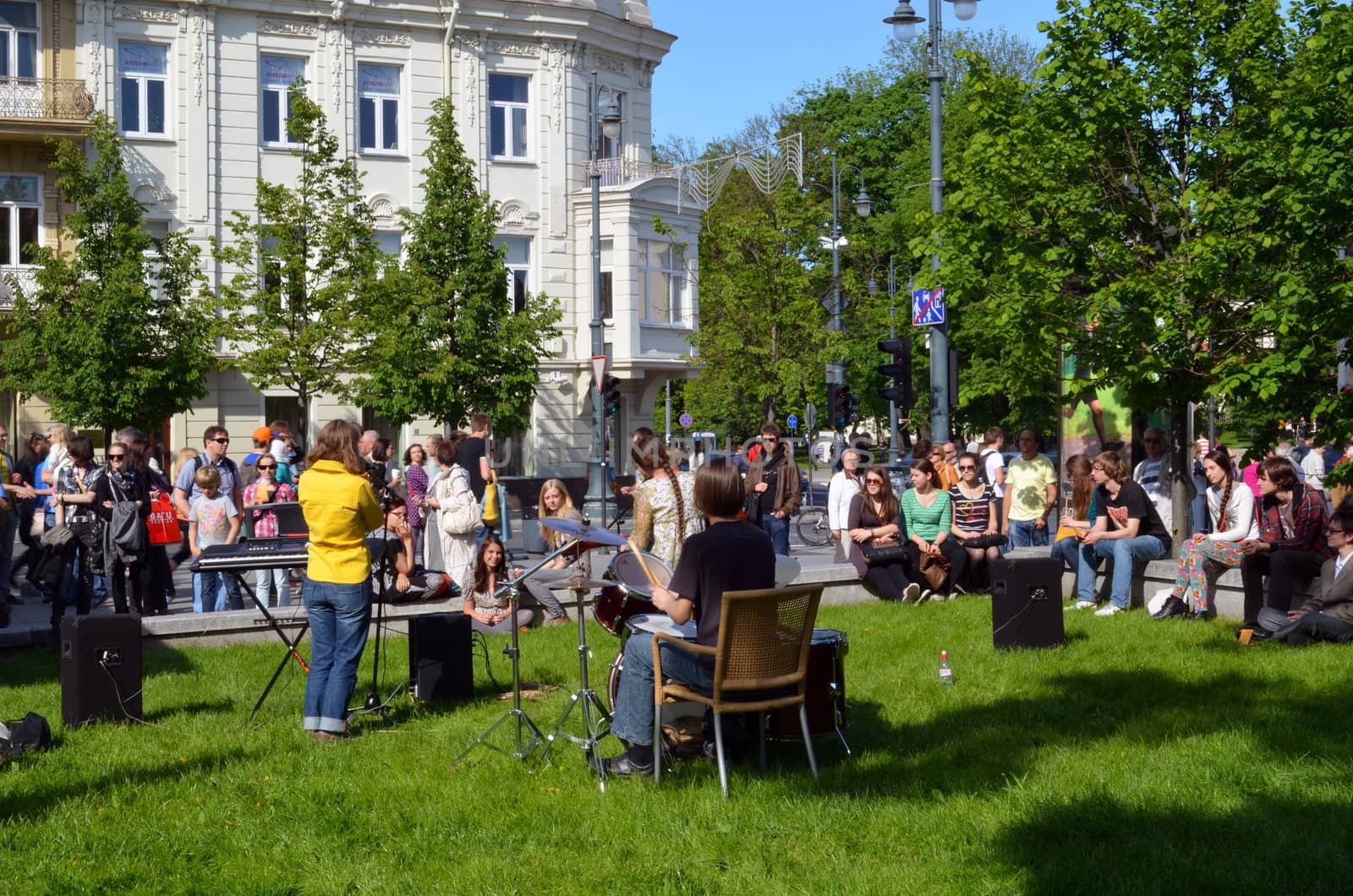 VILNIUS, LITHUANIA - MAY 19: Young unidentified musician play drums and other instrument and sign in street music day on May 19, 2012 in Vilnius. Free event.