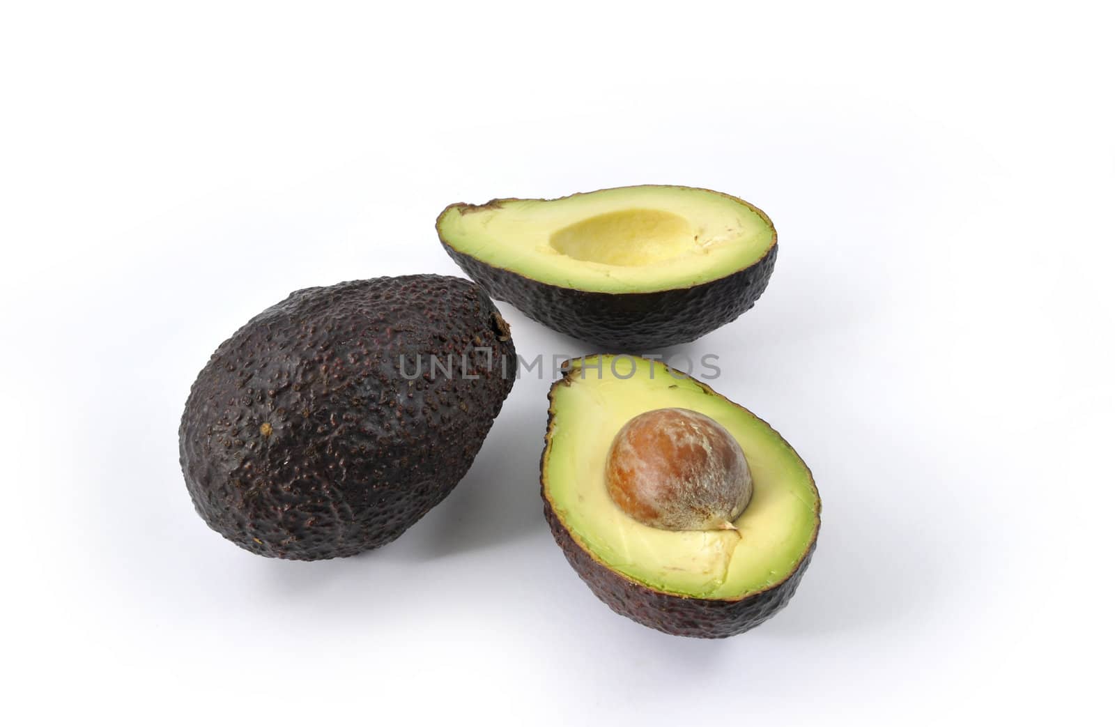 An avocado opened with another one on a white background
