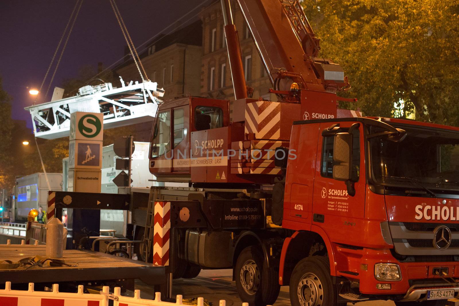 STUTTGART - OCTOBER 25: A truck-mounted crane is lifting a part of the old escalator as workers are installing a new one during renovation works in the metropolitan railway station Schwabstraße in the late evening of October 25, 2012 in Stuttgart, Germany