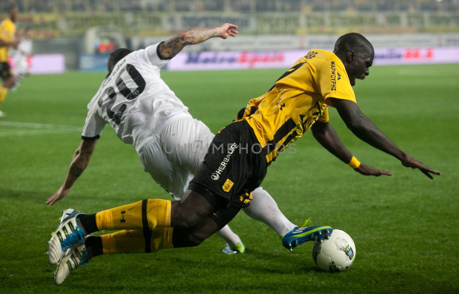 Claiming the ball between players of football teams Paok and Ari by Portokalis