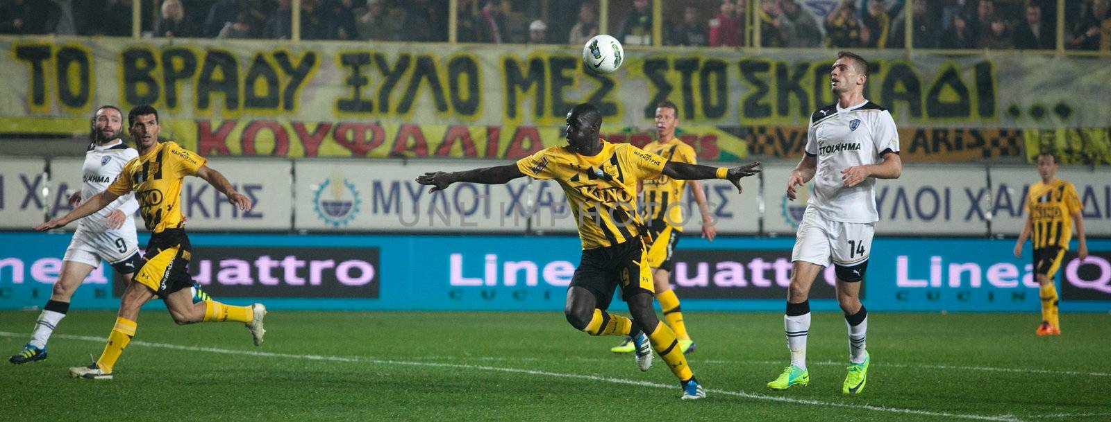 Claiming the ball between players of football teams Paok and Ari by Portokalis