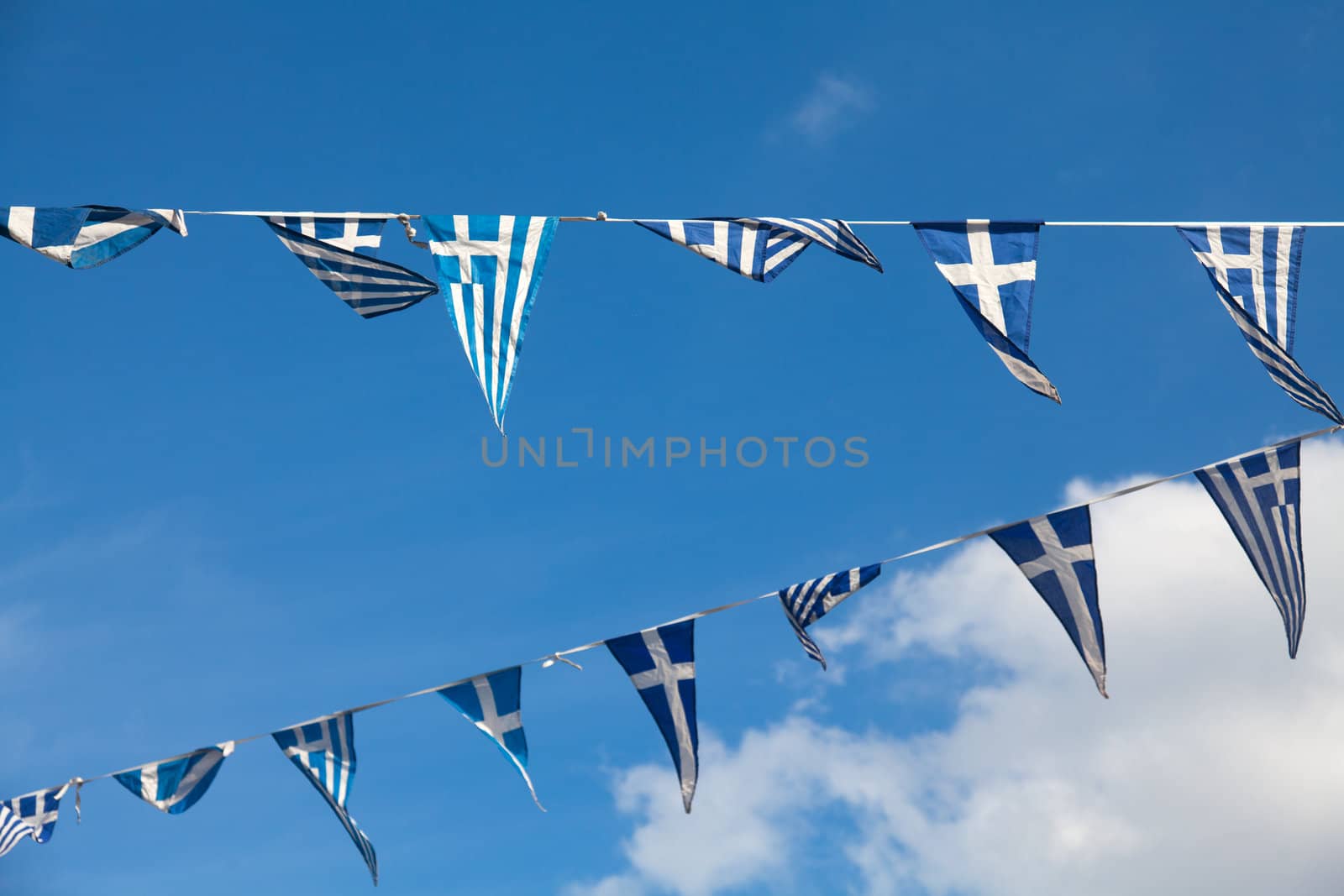 Triangular pennants of the Greek flag on a blue sky