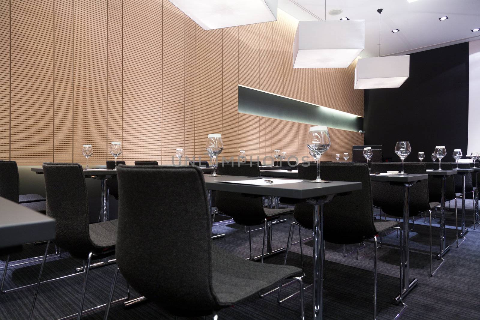 Meeting room interior with table, raw of chairs and block-notes,decorat ed in black and white tones