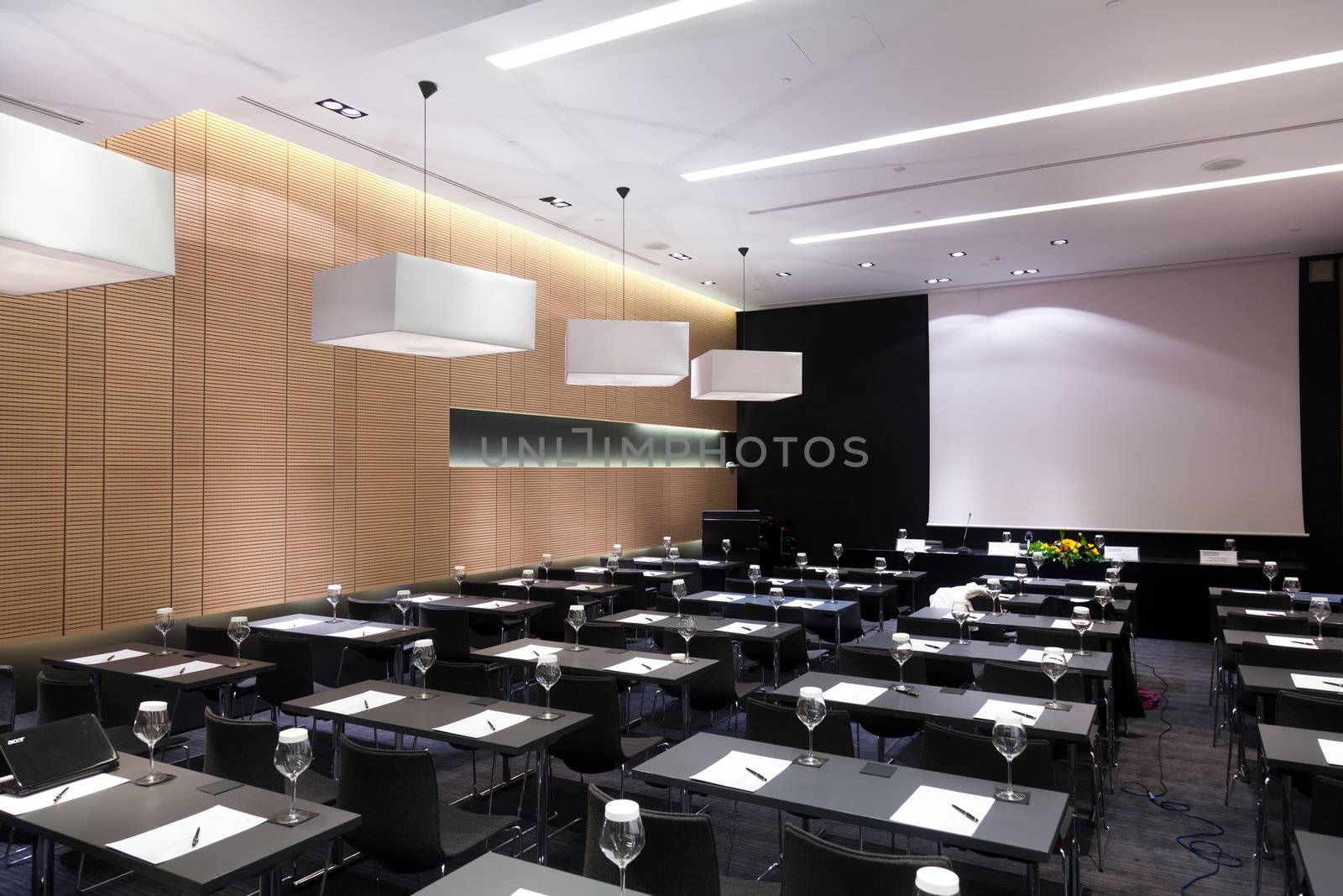 Meeting room interior with table, raw of chairs and block-notes,decorat ed in black and white tones