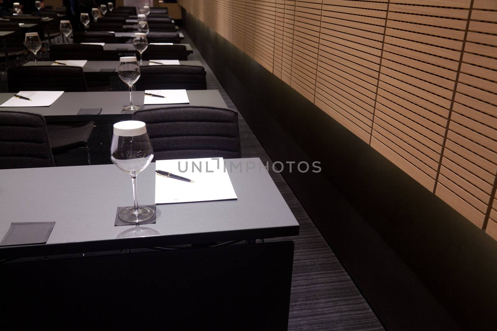 Meeting room interior with table, raw of chairs and block-notes,decorat ed in black and white tones