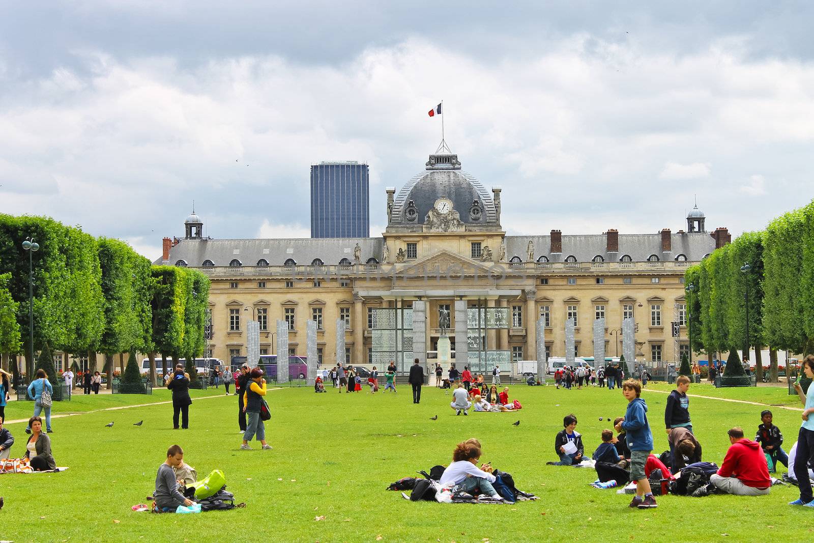 Parisians and tourists on lawn Champs de Mars in Paris. France by NickNick