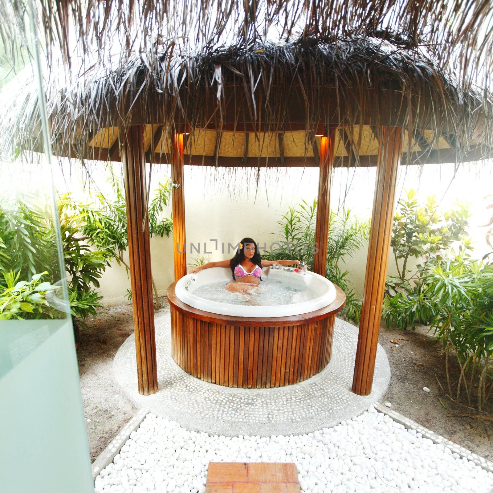 Pretty woman relaxing in jacuzzi of tropical hotel