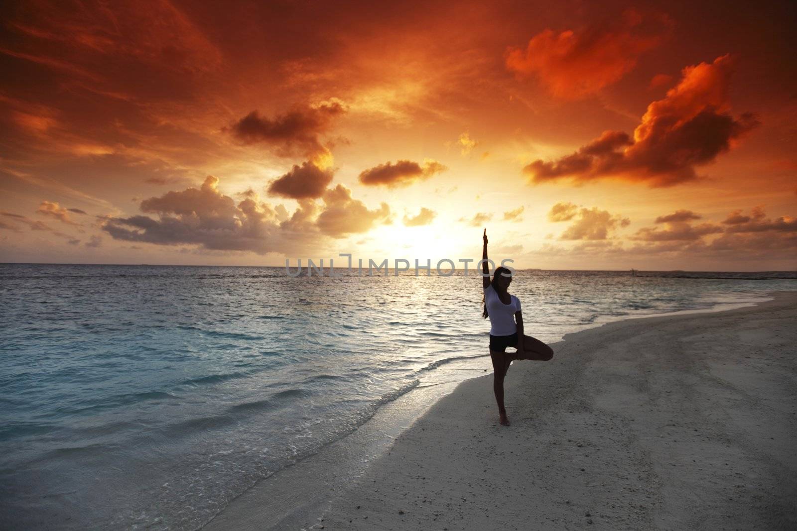 Yoga woman on beach at sunset by Yellowj