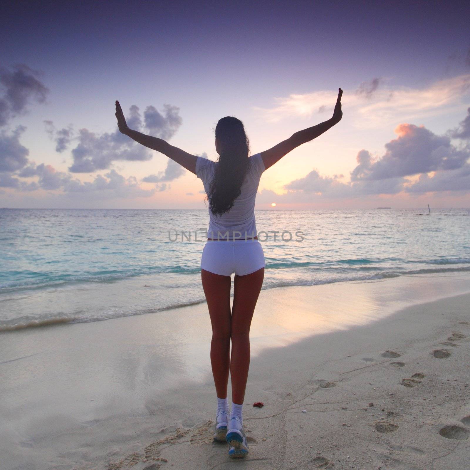 Woman in sportswear posing on beach in the morning