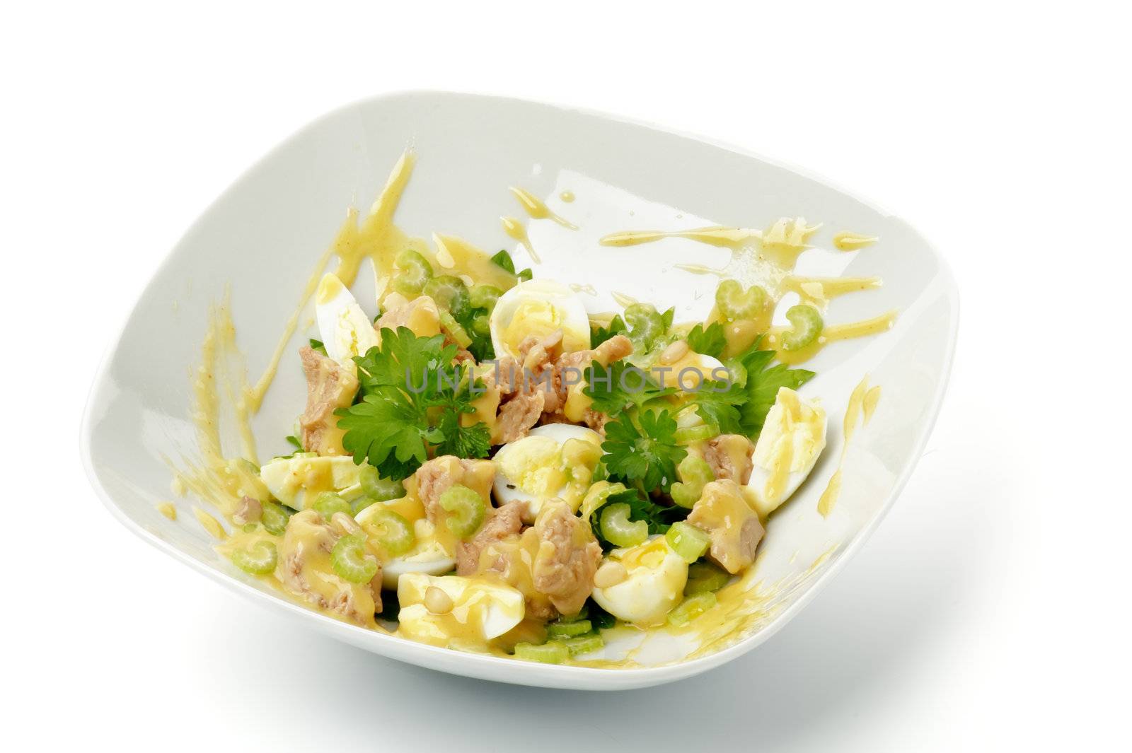 Delicious Salad with Cod Liver, Quail Eggs and Parsley in White Bowl isolated on white background