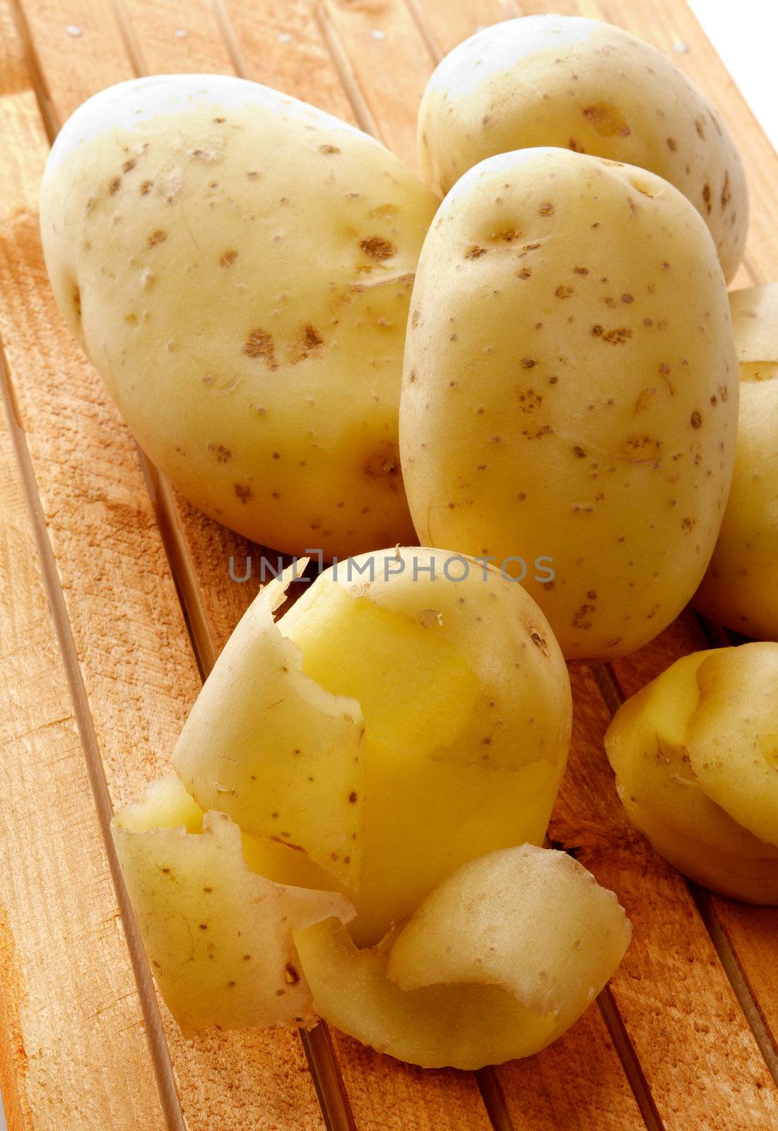 Perfect Raw Potato Full body, Slices and Rind closeup on Wood background