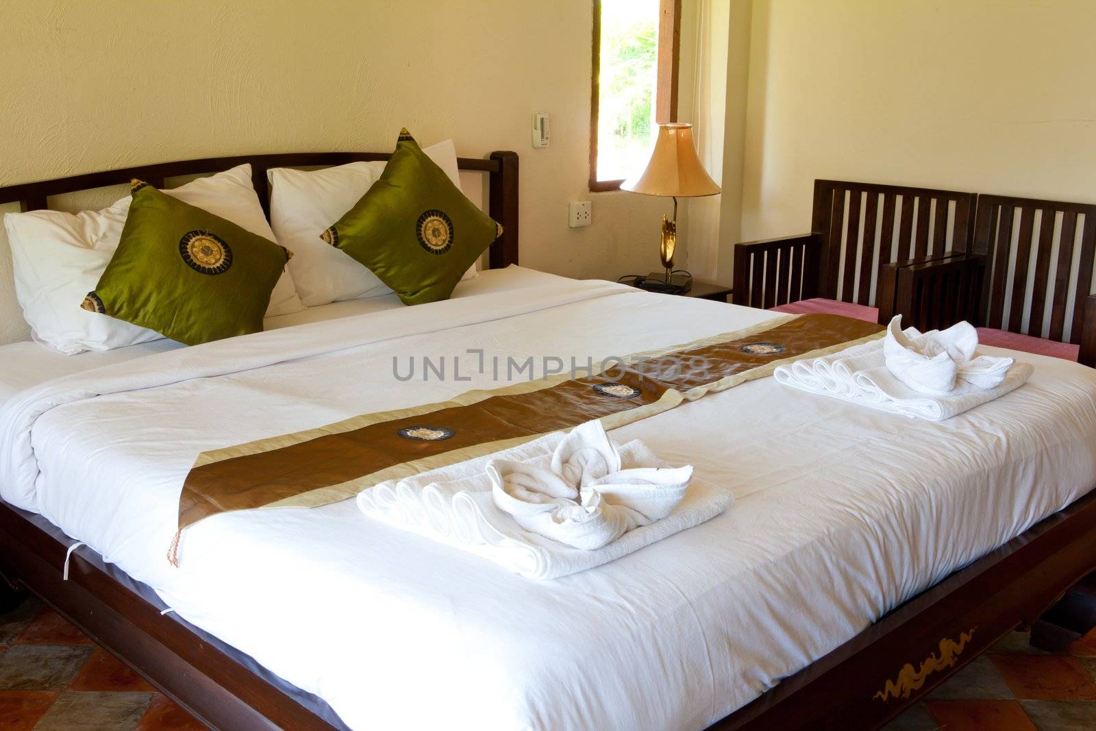 Hotel room in a tropical resort with bed and wooden flooring