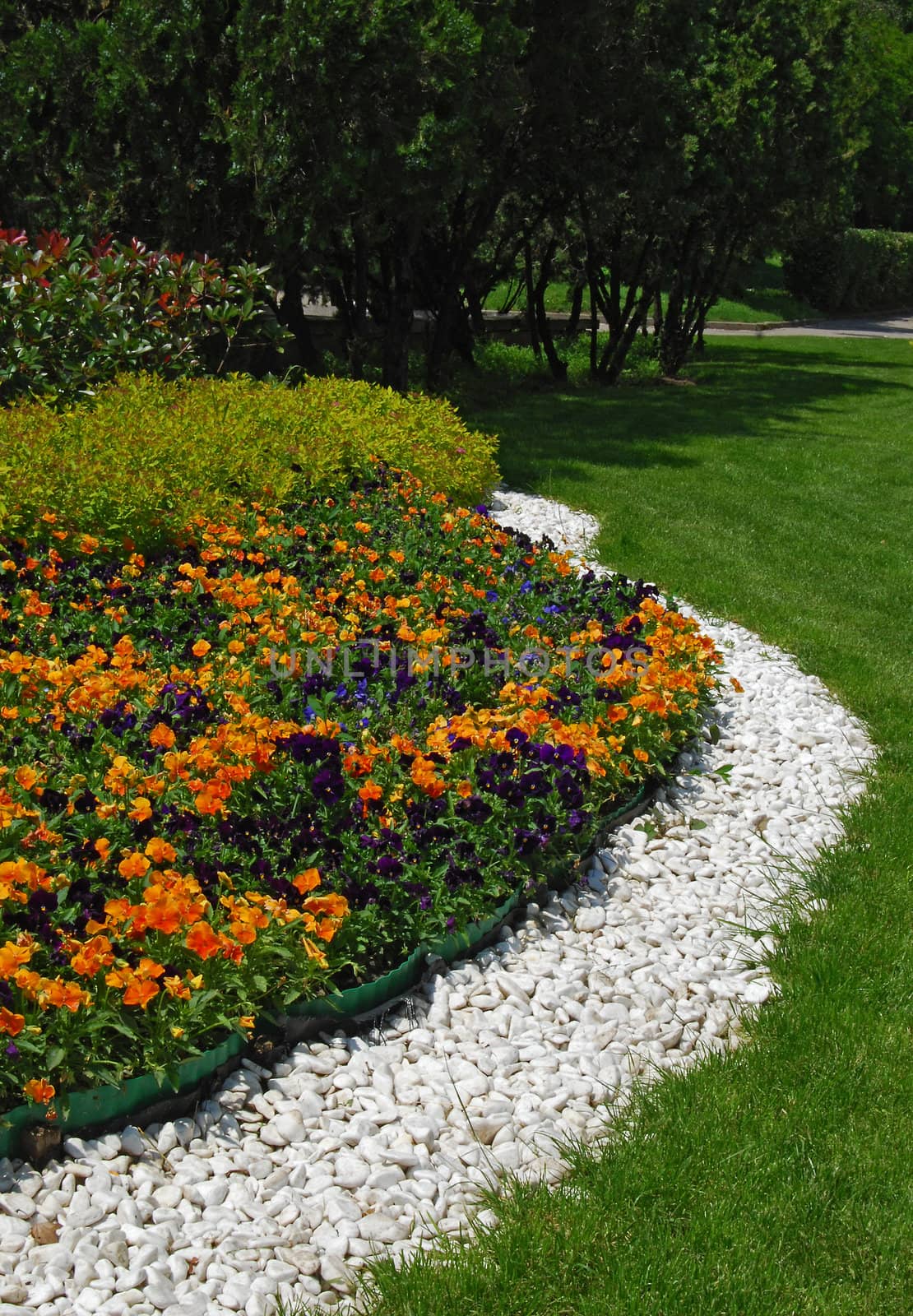 Flowerbeds, white gravel, grass, plants in park