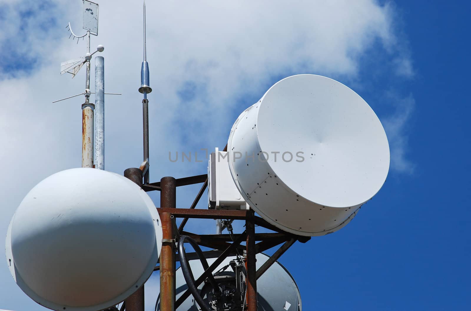 Mountain peak antennas and communication equipment closeup on blue-sky background