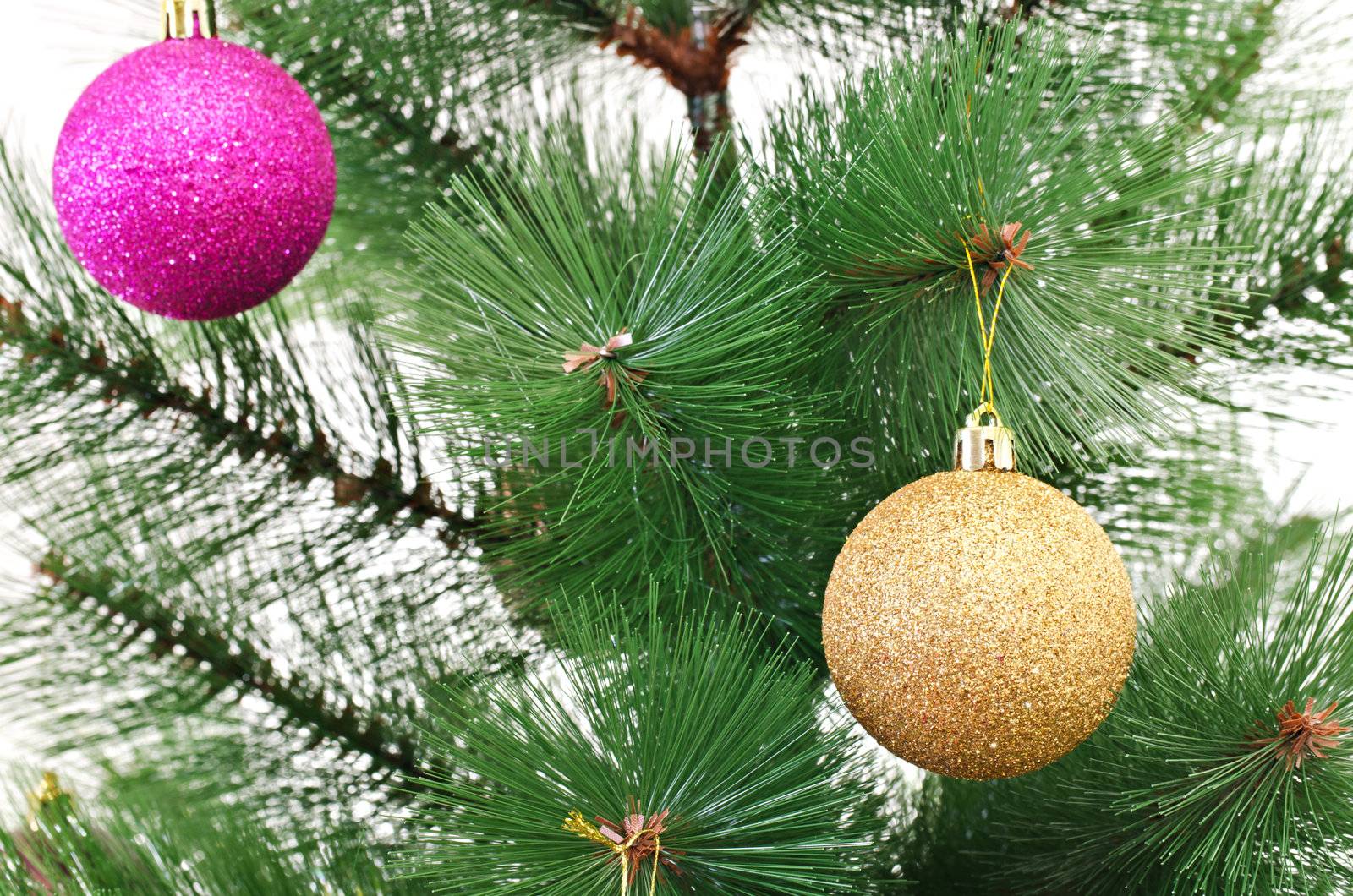 Detail of plastic Christmas tree with hanged shiny baubles