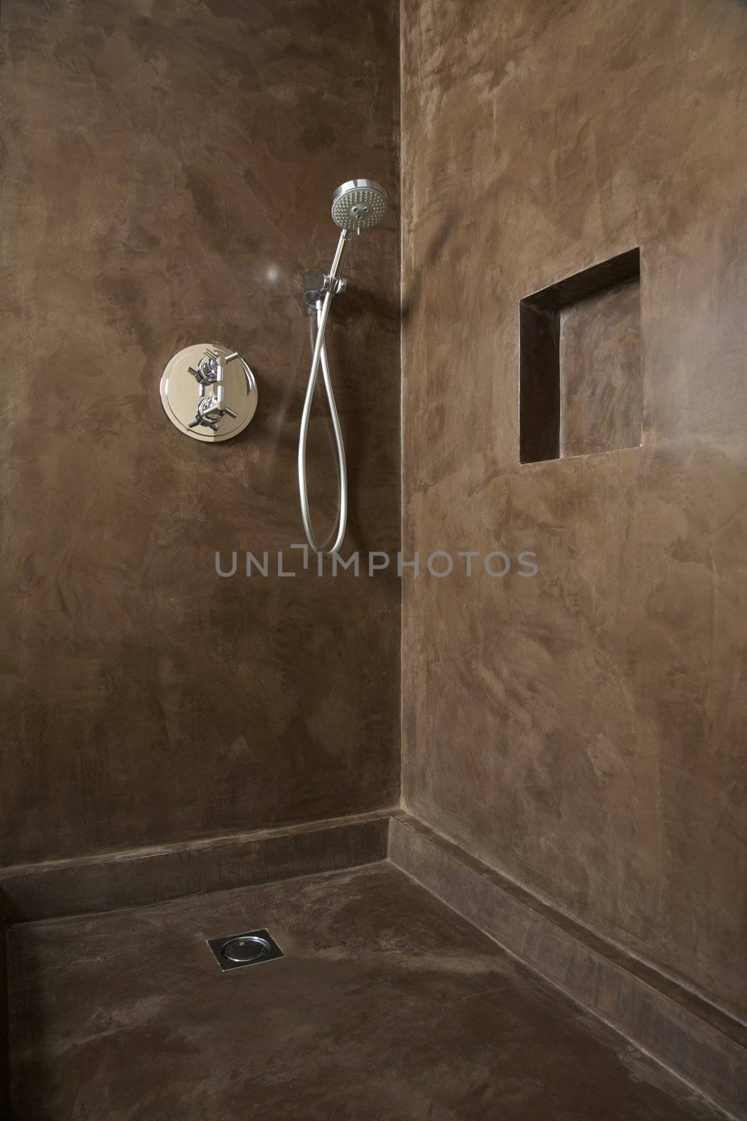 hand shower equipment on brown wall of bathroom