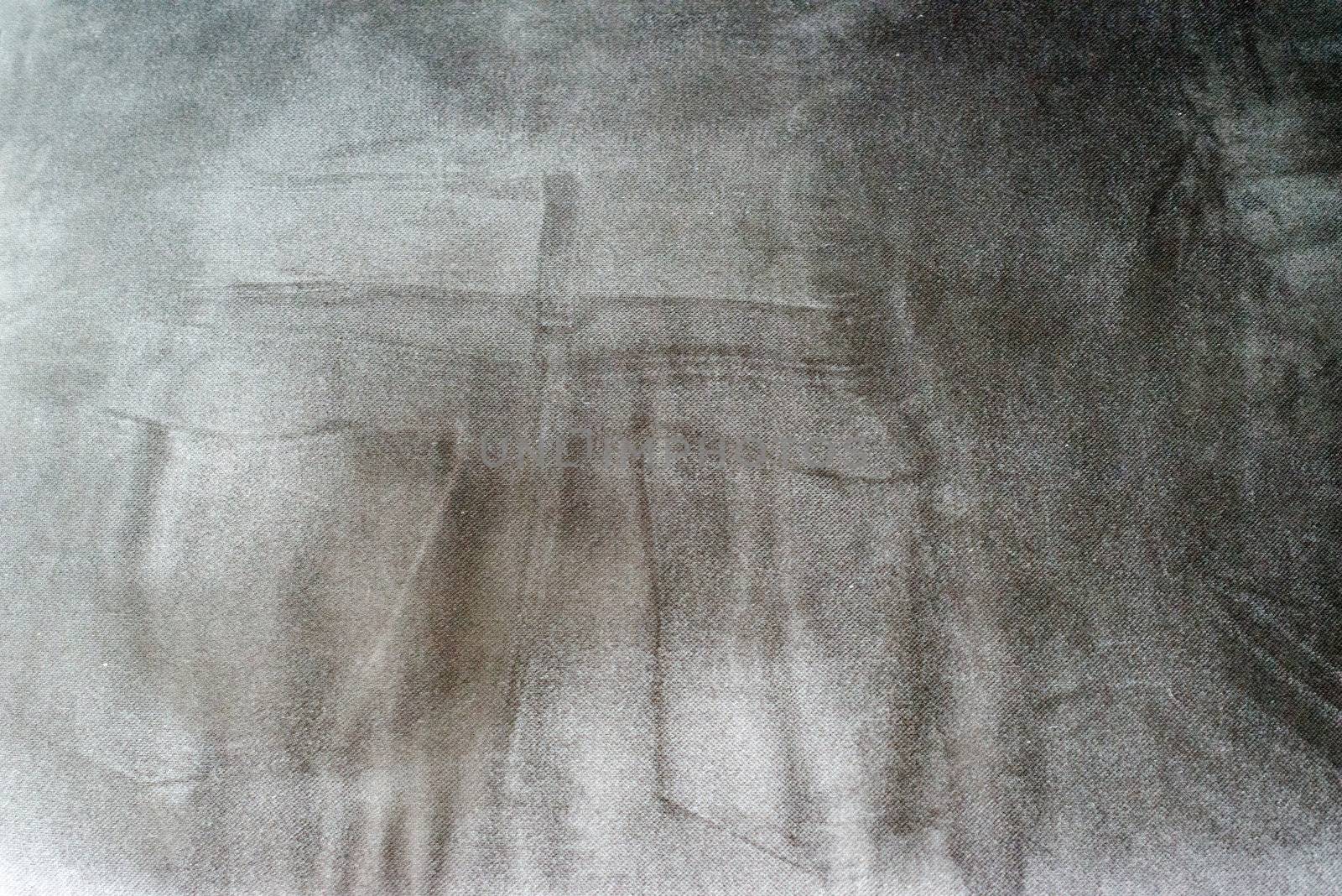 Abstract: Imprint of someone in jeans sitting on a dark gray sofa