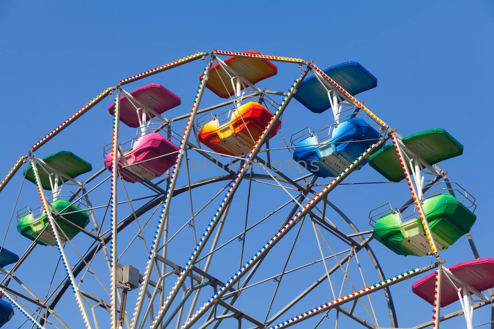 Brightly colored Ferris wheel against the blue sky