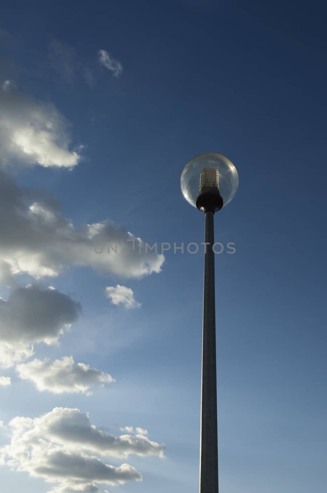 Modern spherical street light against a cloudy dramatic blue sky