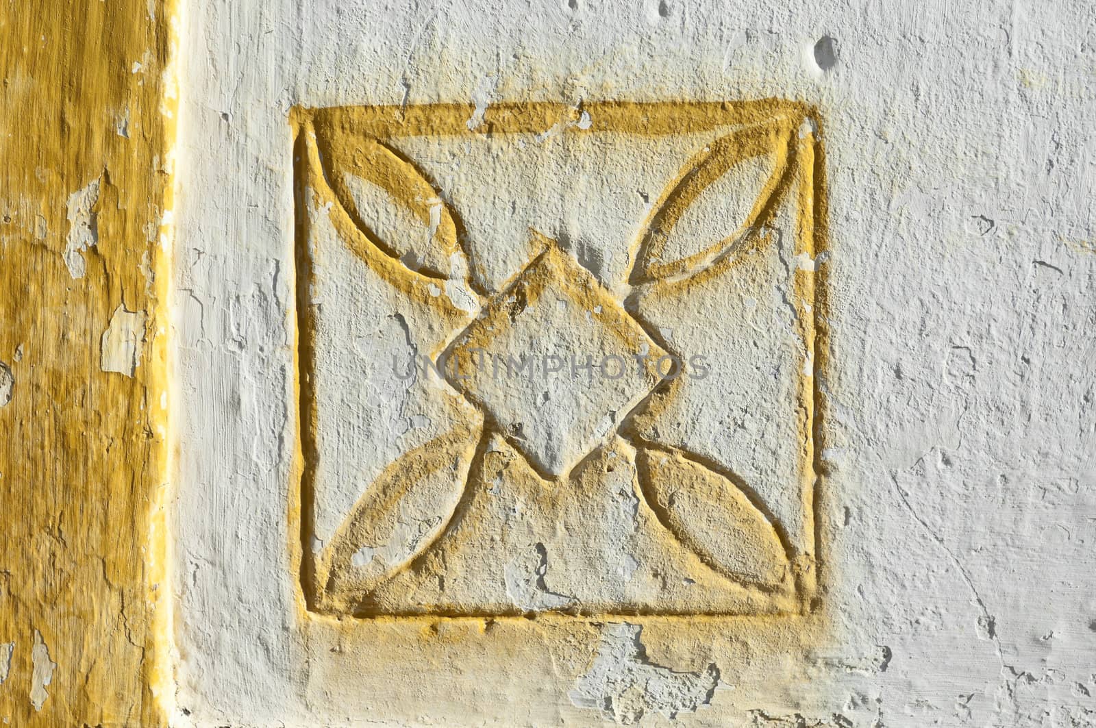 Traditional geometric motif painted in yellow carved on a whitewashed wall, Alentejo, Portugal