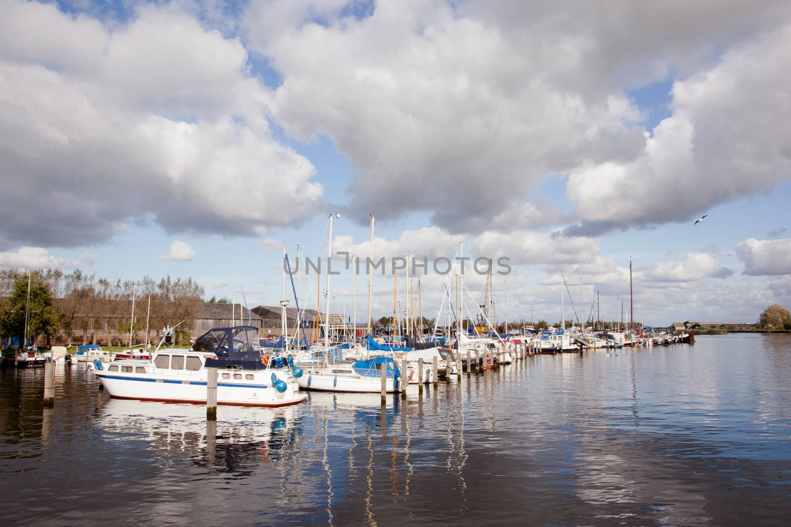 Dutch harbour with boats and clouds in blue sky