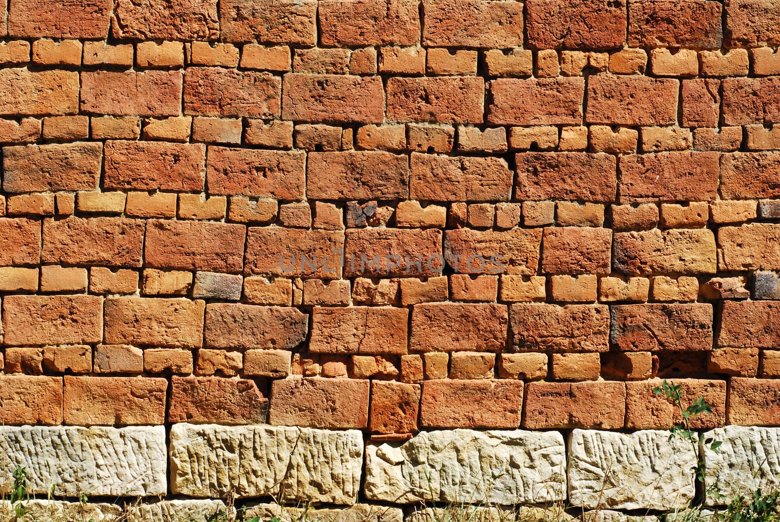 Old country house red bricks wall stone base as background