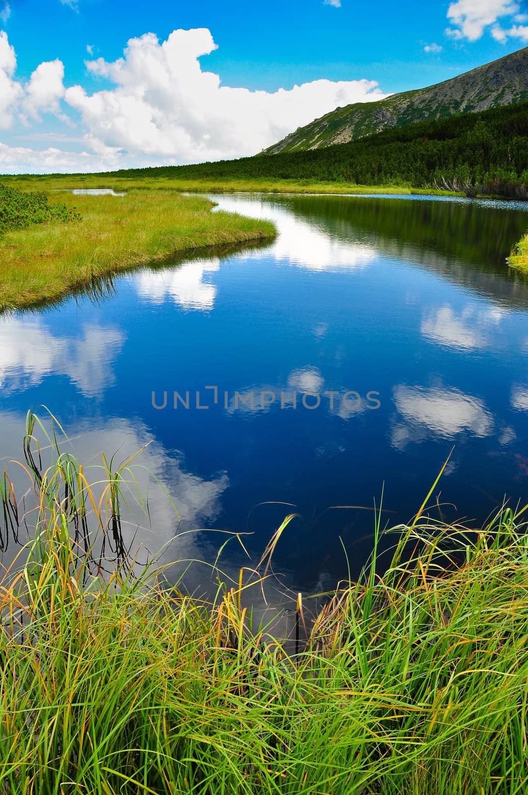 Mountain lake with sky and white clouds reflection, Slovakia