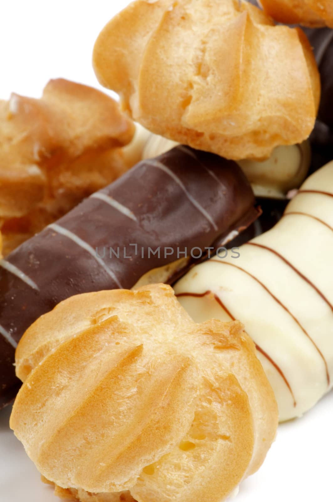 Arrangement of Eclair with Dark and White Chocolate Glaze and Profiterole closeup on white background