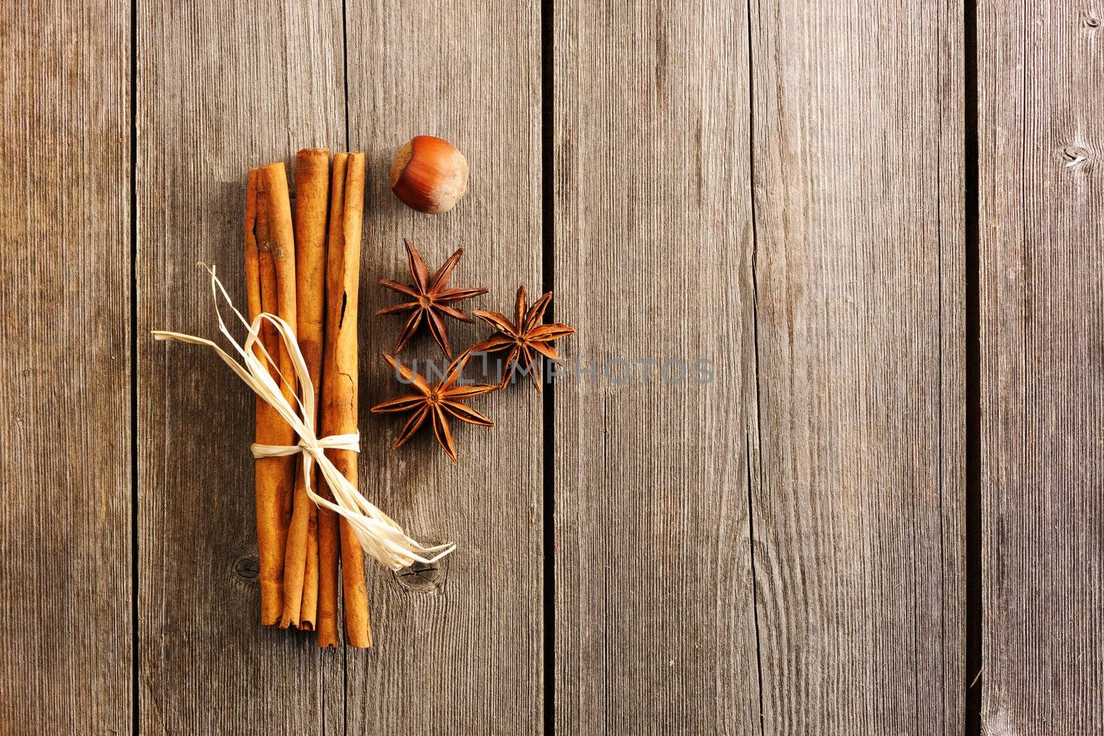 Cinnamon sticks and other spices over wooden table