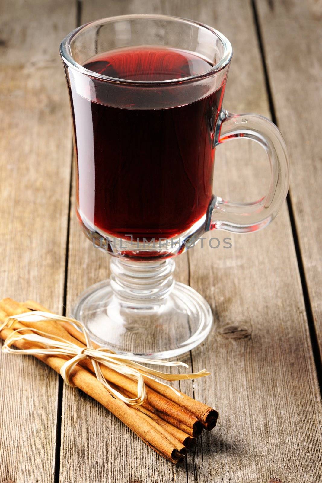 Glass of red mulled wine on wooden table