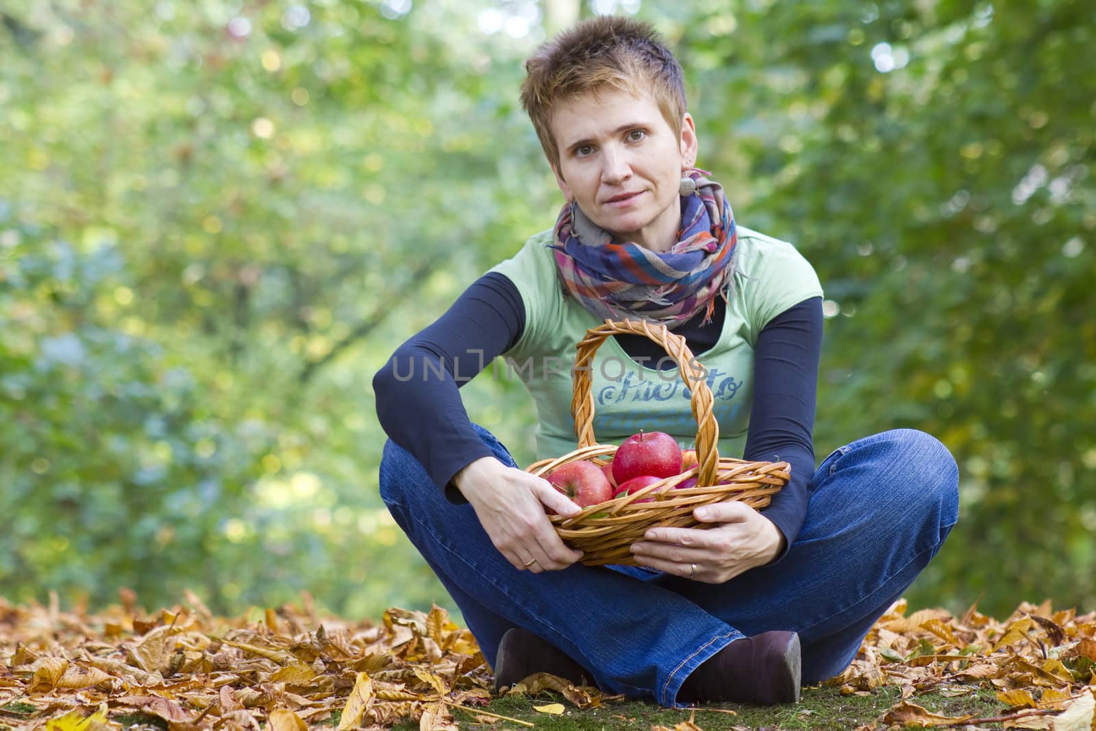 woman with a basket full of red apples  by miradrozdowski