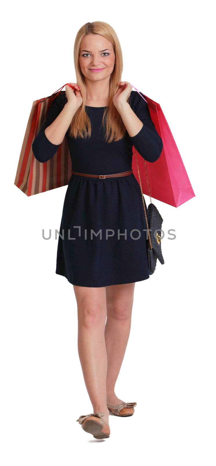 Young blonde woman with two shopping bags walking to the camera against a white background.