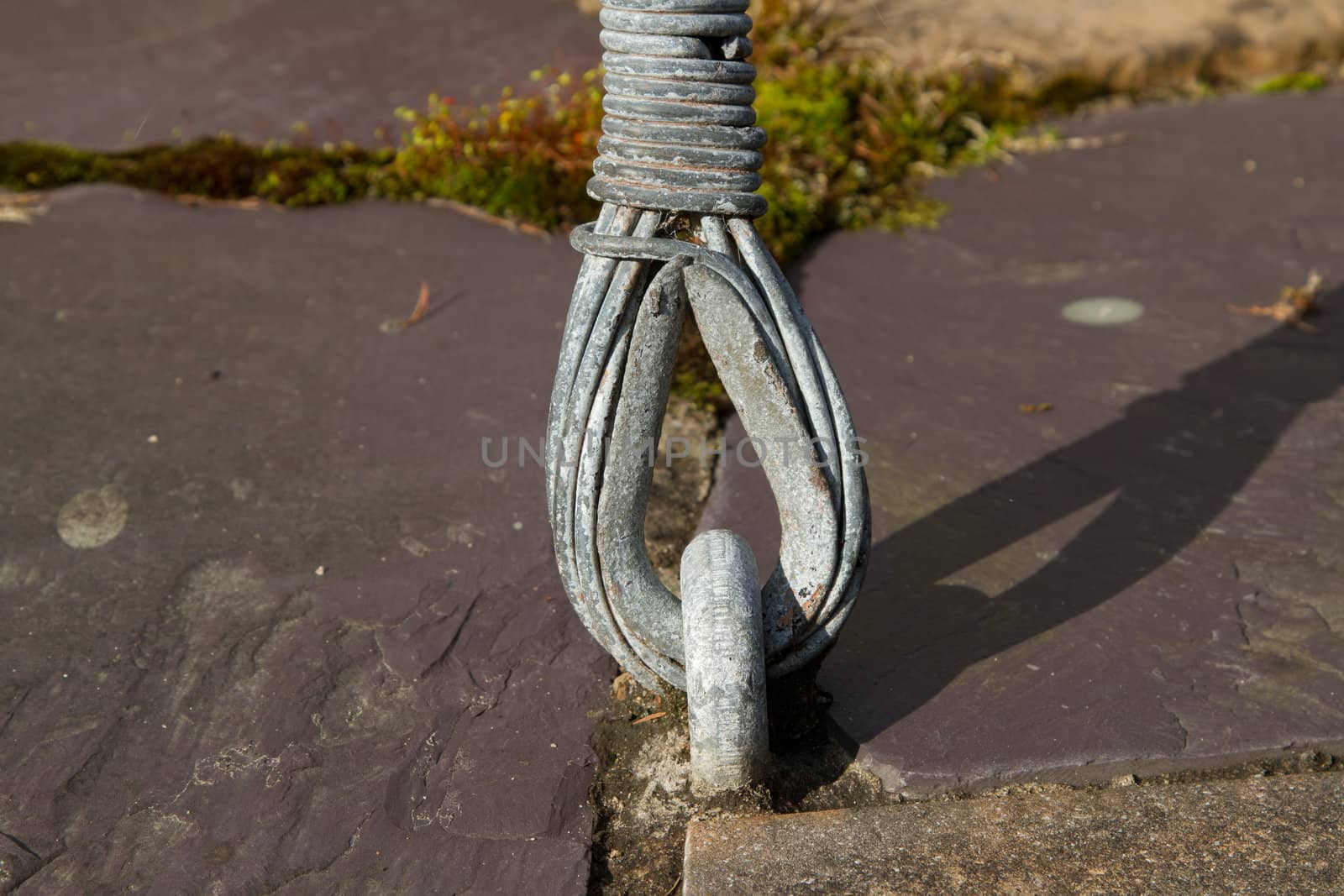 A metal ring fixed to the floor with a cable end hooked through it.